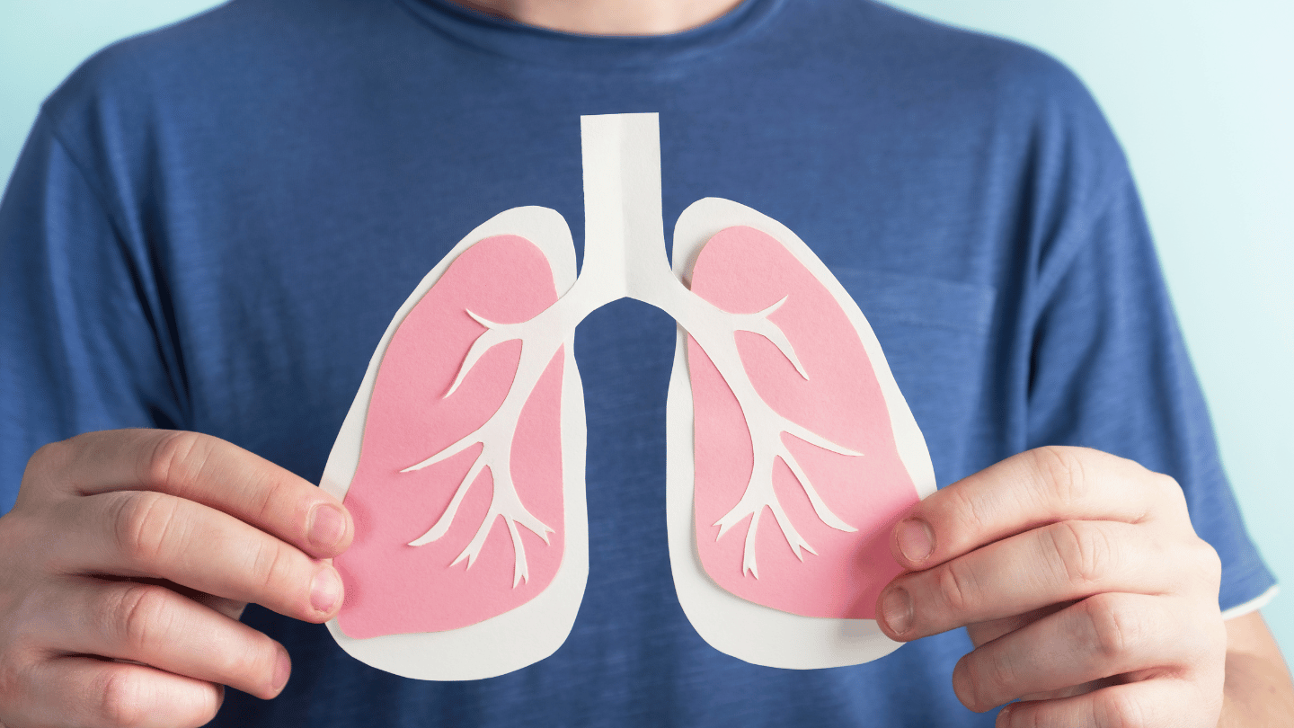 Man holding up diagram of lungs, representing TB health and the QuantiFERON test for TB