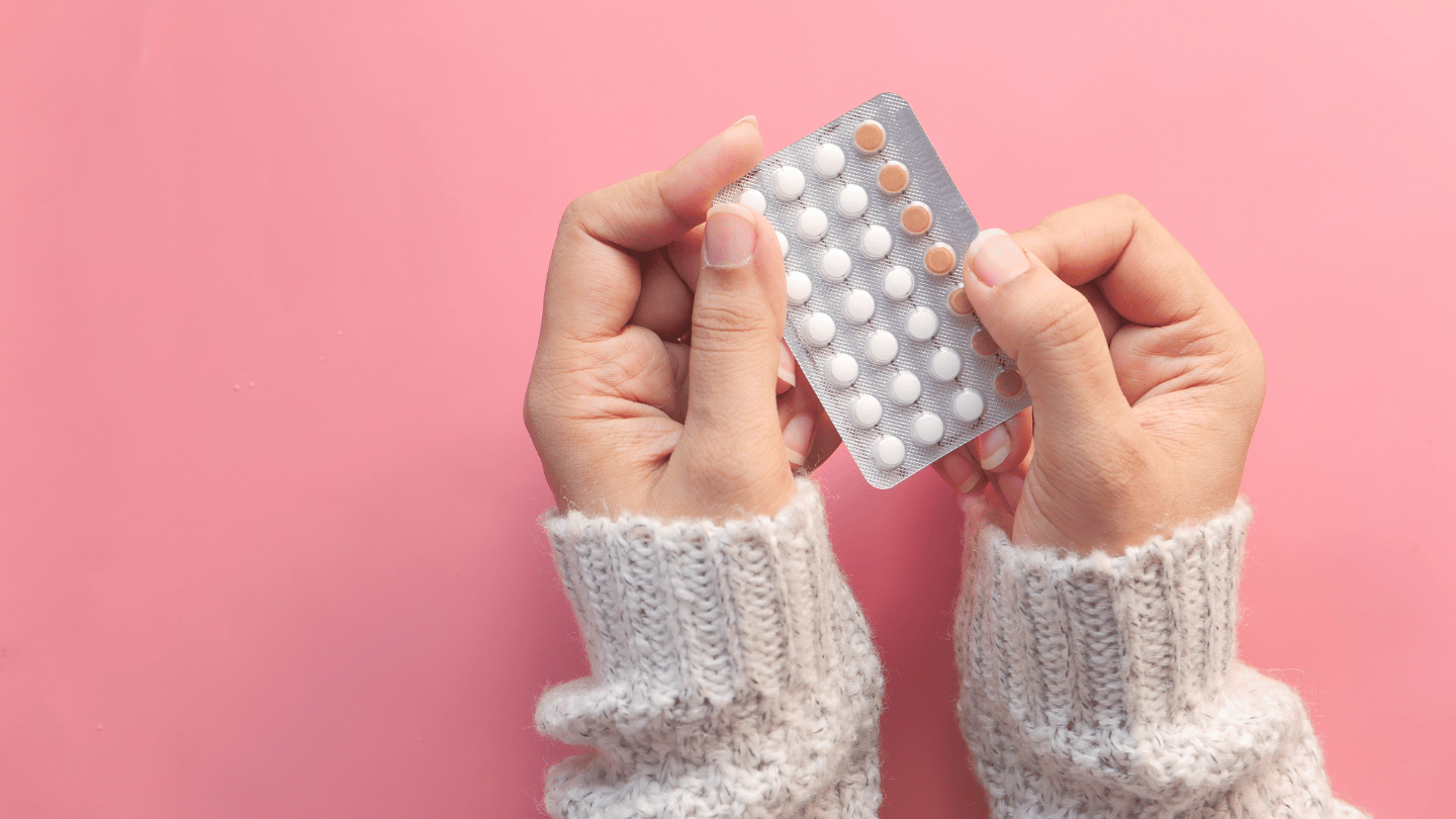 Woman holding oral birth control pills