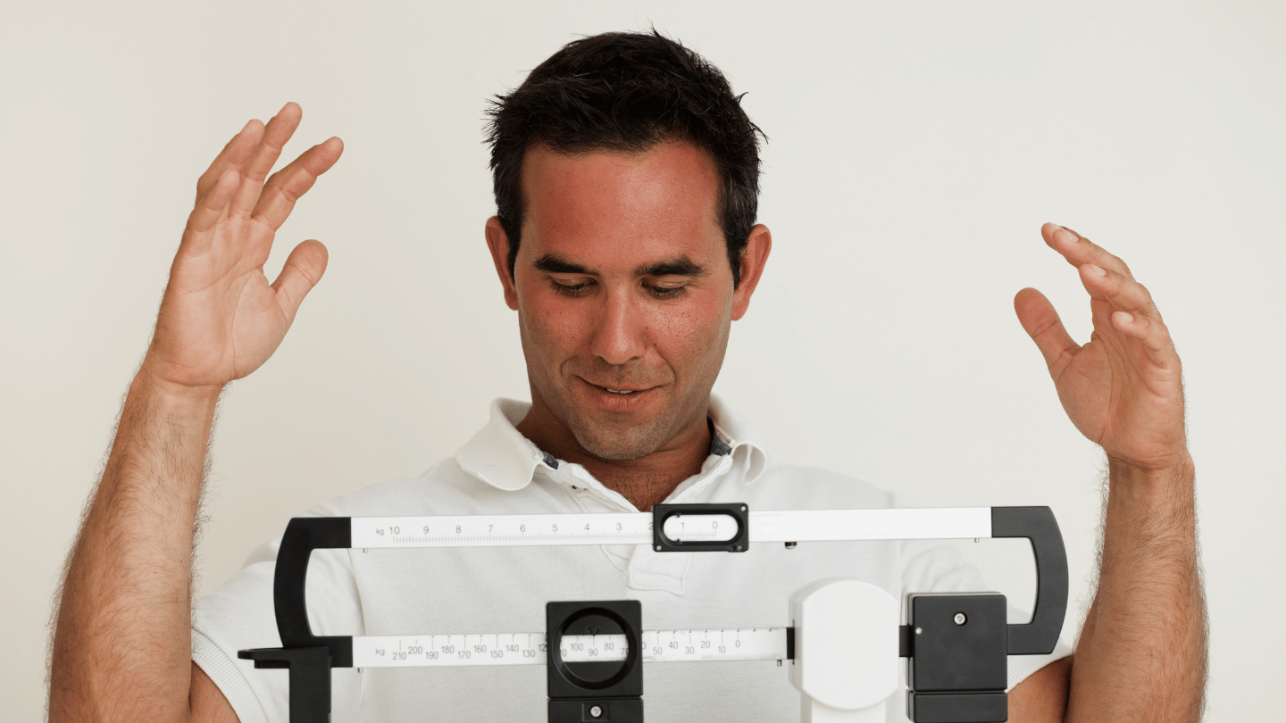 Man excitedly tracking weight loss progress on a scale, symbolizing positive results from weight loss Ozempic results