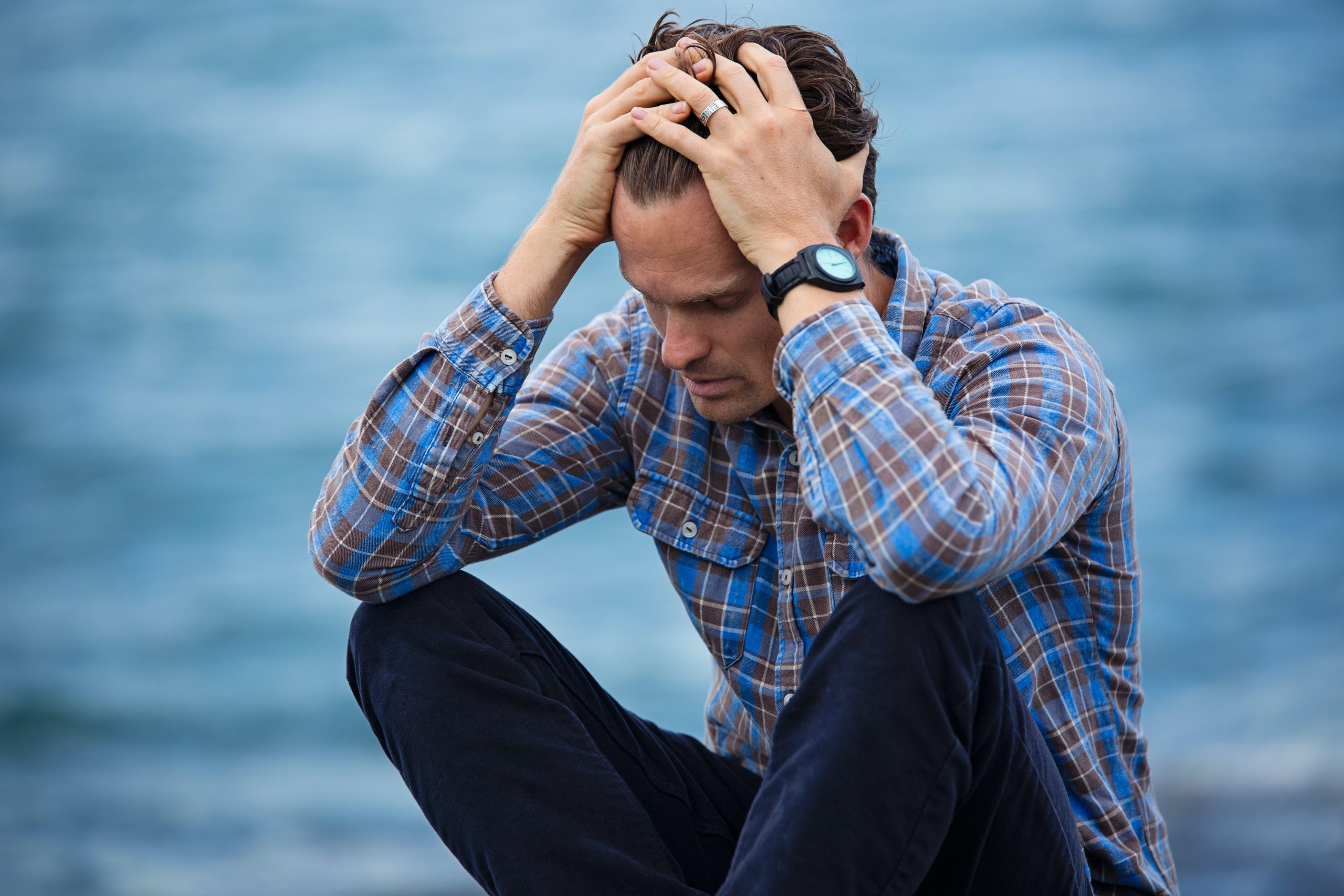 Man holding his head, experiencing anxiety symtpoms